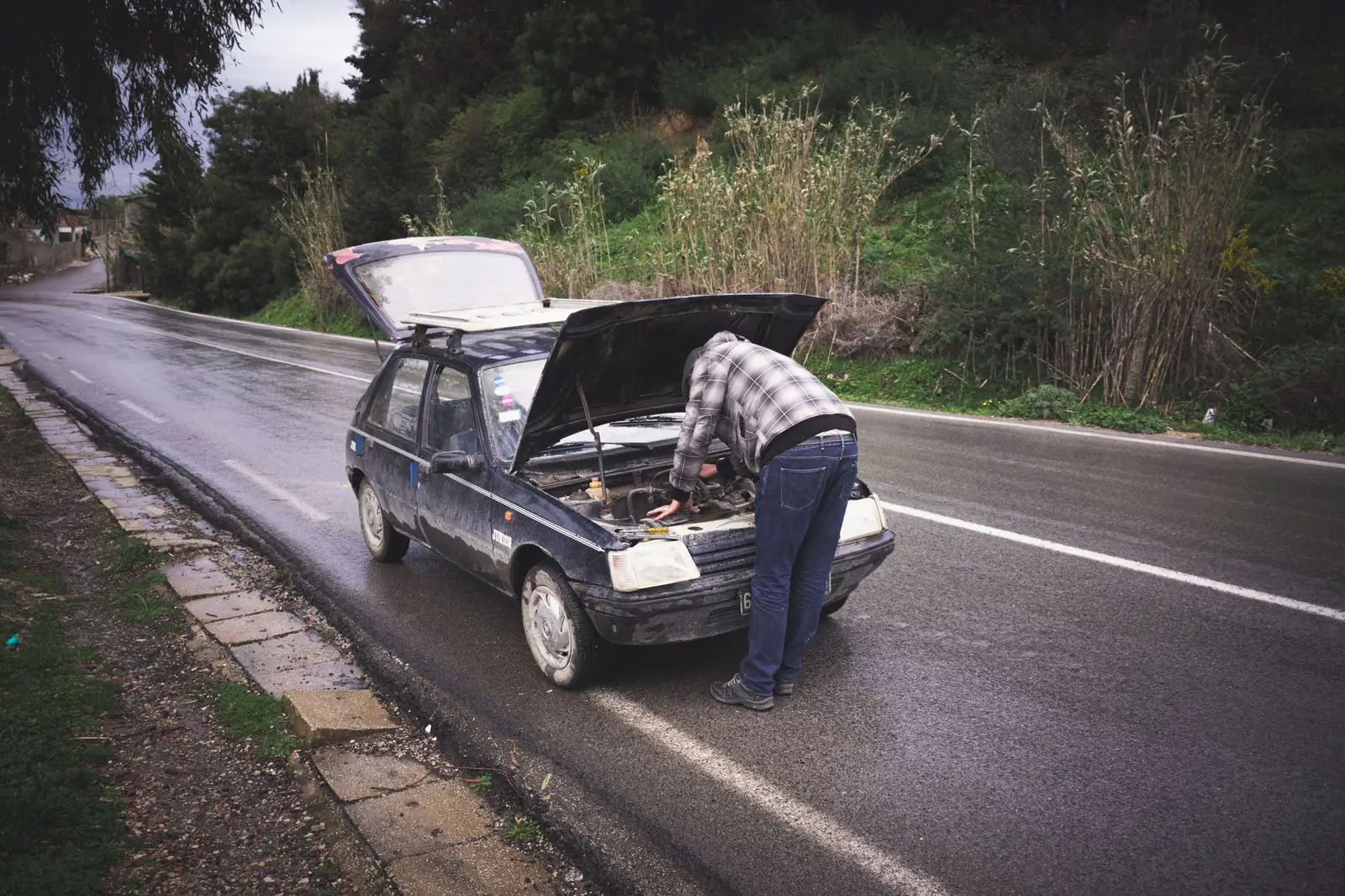 Pannenhilfe an einem Auto auf nasser Landstraße