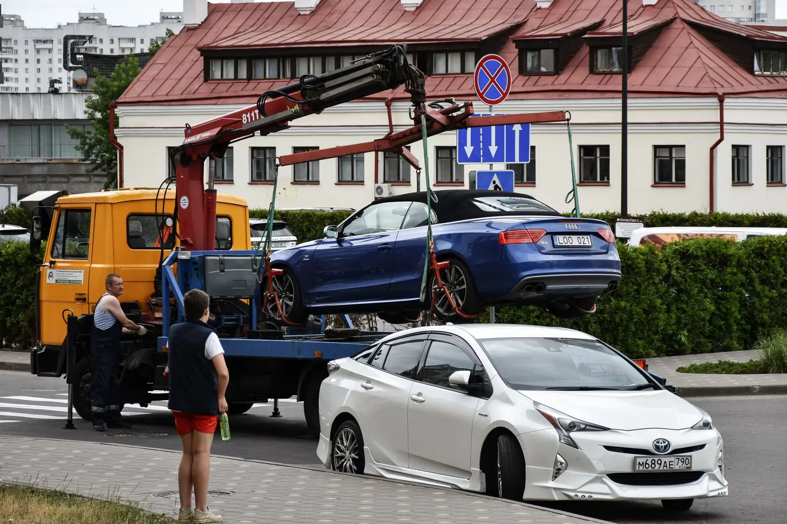 Ein verunfalltes Auto wird per Kran auf einen Lkw gehoben