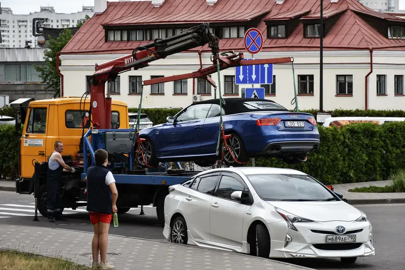 Ein verunfalltes Auto wird per Kran auf einen Lkw gehoben